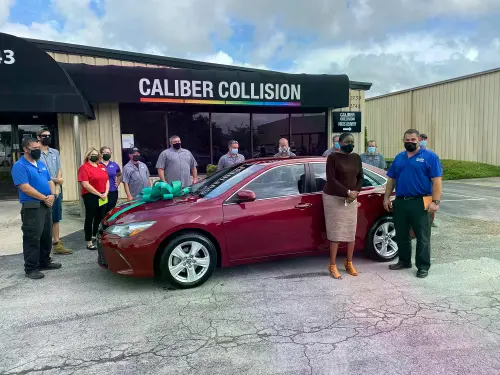 The happy recipient and the Caliber Collision team at an NABC Recycled Ride giveaway event.