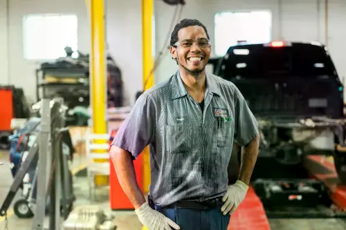 Caliber Collision Body Repair Tech in center garage.