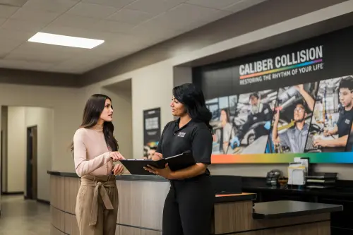 Caliber Collision Service Advisor discussing repair process with customer.